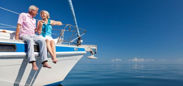 Older couple embracing on a boat overlooking a body of water